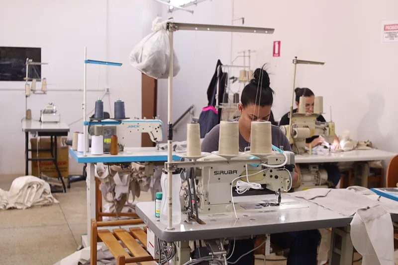 Salão de costura da fábrica, com as máquinas em linha